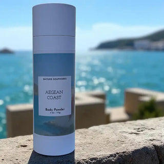 Body powder container labeled 'Aegean Coast' by Bayside Soapworks with a coastal background.