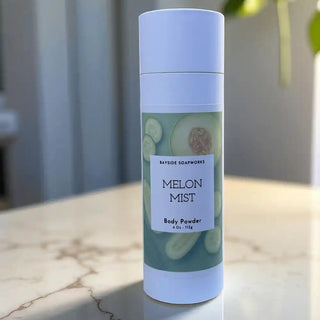 Body powder can with 'Melon Mist' label on a marble surface