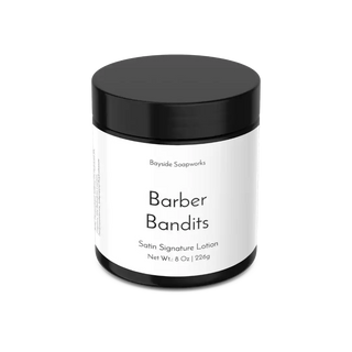 Jar of 'Barber Bandits' satin signature lotion with a black lid on a white background