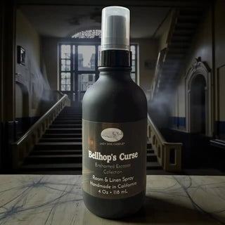 Room & Linen Spray bottle labeled 'Bellhop's Curse' in a dimly lit room with smoke effects.