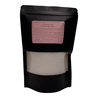 Black packaging of Cherry Kiss Soaking Salts with a pink label on a white background