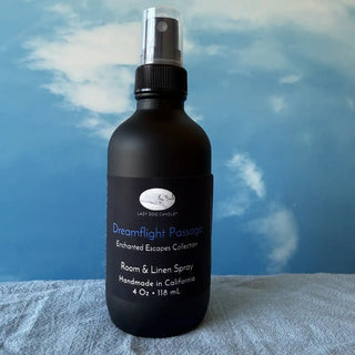 Black room and linen spray bottle with a blue label against a blue sky background
