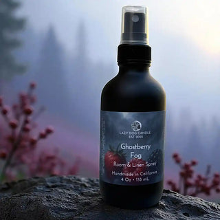 Room & Linen Spray bottle labeled 'Ghostberry Fog' by Lazy Dog Candle with a spooky, foggy background