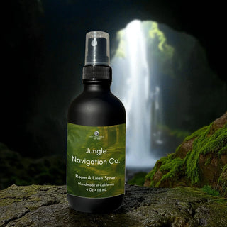 Jungle Navigation Co. room & linen spray bottle with a waterfall in the background