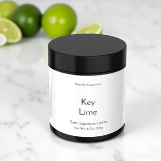 Key Lime satin signature lotion jar with limes in the background