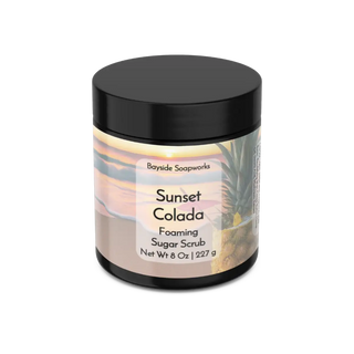 Jar of Sunset Colada foaming sugar scrub with a black lid on a white background