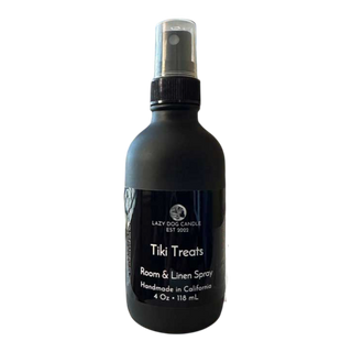 Black room and linen spray bottle labeled 'Tiki Treats' by Lazy Dog Candle on a white background